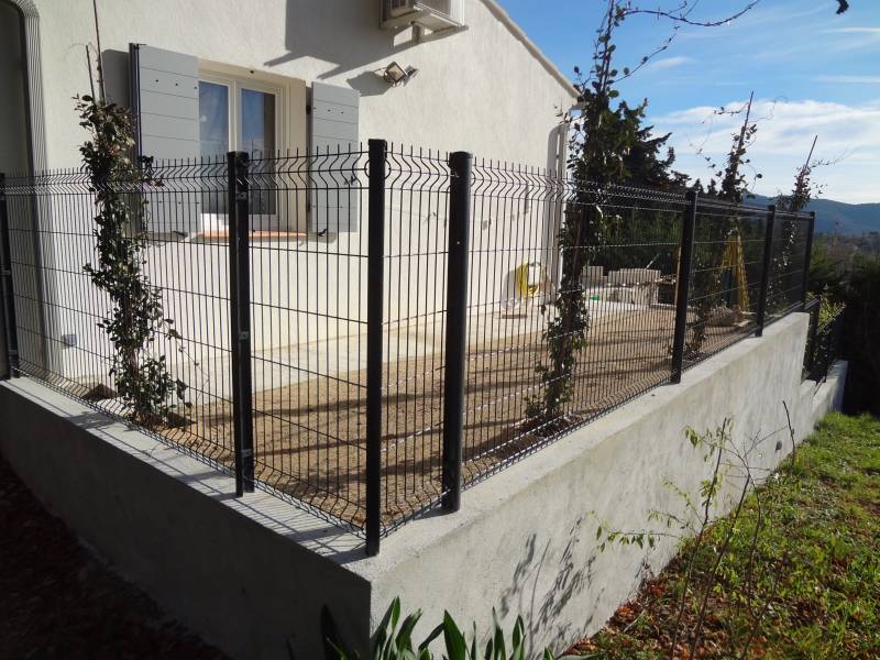 Construction d'un mur de clôture en agglos à bancher avec pose de clôture rigide grise à Carnoules Var 83