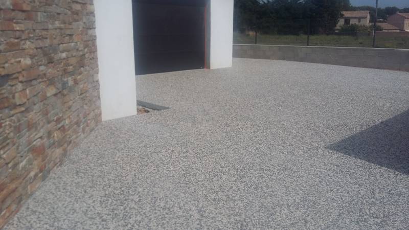 Vos revêtements de sol extérieurs à Cuers: Béton désactivé avec gravier gris dans une cours de maison dans le var