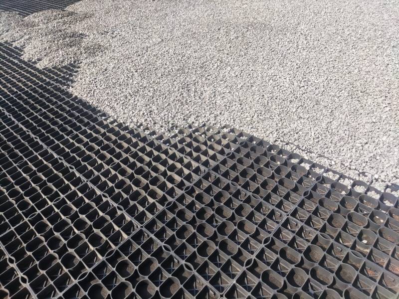 Remplissage des dalles en gravier gris pour parking à Cranoules