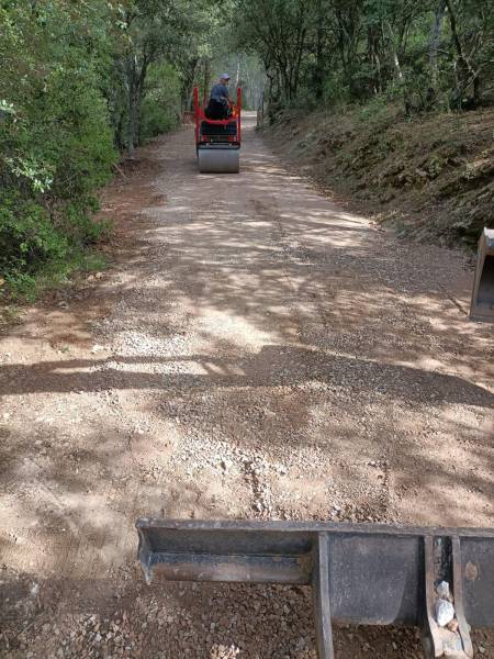 Compactage au cylindre du chemin d'accès suite à l'apport de tout venant pour le rebouchage des trous à Carnoules proche de Cuers 