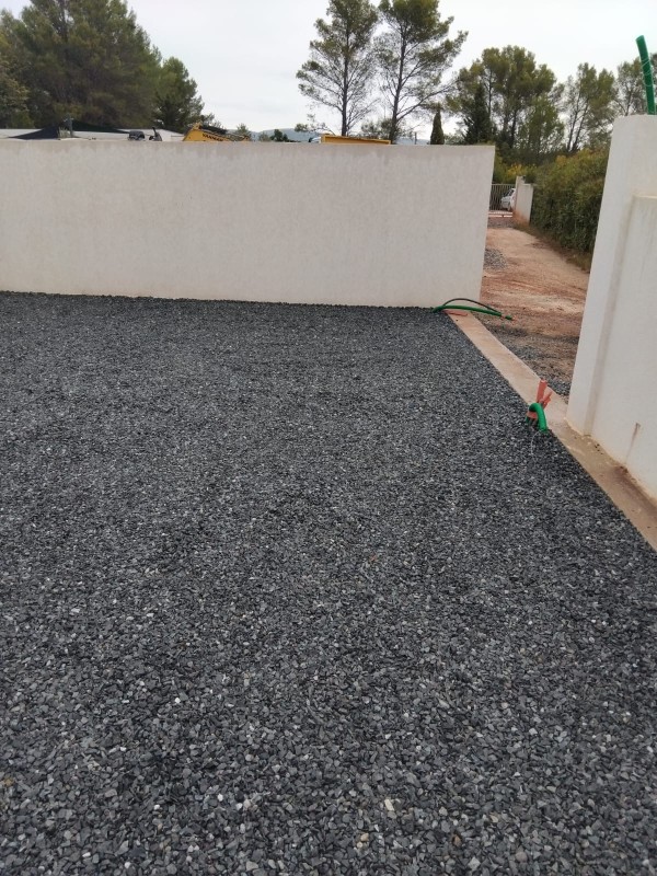 Remplissage des dalles de stabilisation au gravier gris fin autour d'une maison individuelle à Cuers